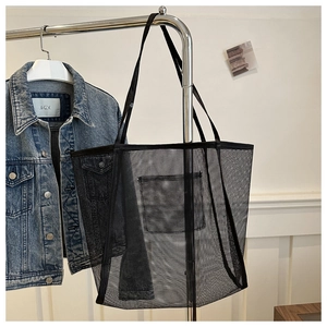 Detail of black mesh tote bag showing transparent texture and internal hanging pocket