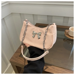 Close-up of pink baguette bag featuring a silver metal bow accent and chain strap
