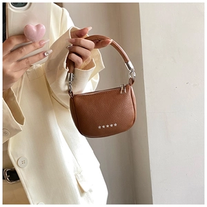 Detail of brown lychee grain leather hobo bag with five silver metal star studs on bottom