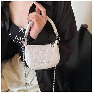 Detail of white lychee leather mini bag with woven handle and star metallic charms