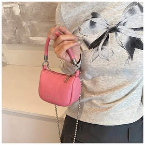 Detailed close-up of pink pebbled leather mini saddle bag with silver star rivets