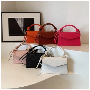 Detail of colorful small square bags with knotted handles and lychee grain leather texture