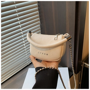 Macro detail of creamy white lychee grain leather mini bag with silver star rivets