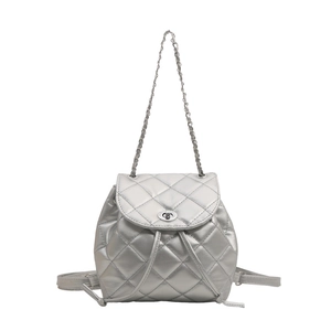 Silver quilted backpack with metallic chain straps and turn-lock closure on white background