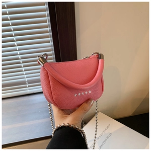 Detailed shot of pink saddle bag with star rivets and silver bead chain strap