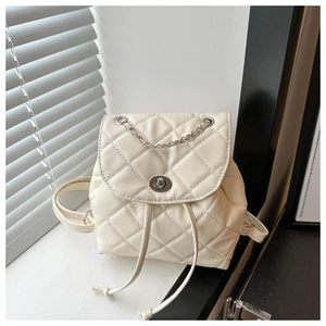 Detail of cream quilted leather backpack with silver chain handle and twist lock closure