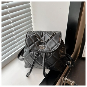 Detail of black quilted PU leather backpack featuring silver twist lock and chain strap