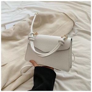 Detail of white lychee leather texture with knot handle and gold metal ring buckle
