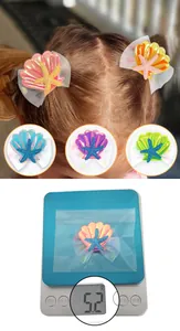 Detail view of colorful glitter mermaid shell hair clips for kids on model and scale