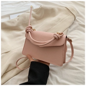 Detailed macro view of pink litchi grain leather texture and gold metal hardware
