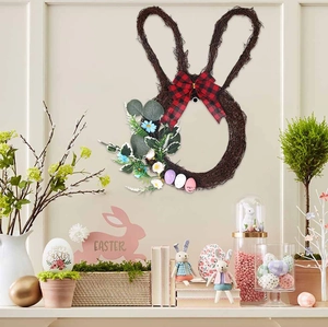Detail van paashaas rotan krans met geruite strik, gekleurde eieren en lentebloemen