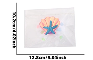 Detail view of shell hair clip with blue starfish and pink sequins on white background