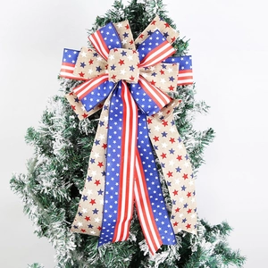 Patriotic USA flag burlap bow with stars and stripes hanging on a snowy Christmas tree