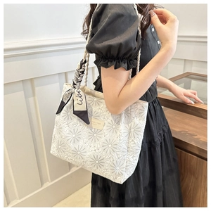 Detail of white canvas tote with daisy embroidery and decorative printed silk scarf