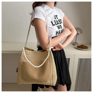 Détail du sac fourre-tout en paille avec poche en cuir marron et anses en corde de coton