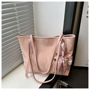 Détail du sac cabas rose avec texture plissée et ruban décoratif imprimé mode élégant
