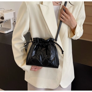 Close-up of black quilted drawstring bucket bag with elegant rhombus pattern detailing