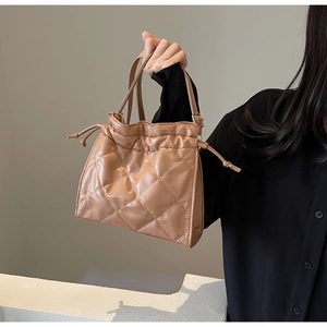 Detail of apricot quilted PU leather crossbody bag with drawstring closure and soft texture