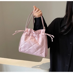 Detail view of the pink quilted bucket bag with drawstring closure and glossy finish
