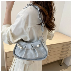 Detail of silver pleated cloud bag with ruffled strap and pearl flower chain decoration