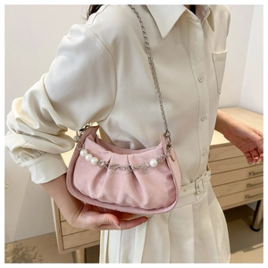 Detail of light pink pleated cloud bag with silver chain and pearl flower charm strap