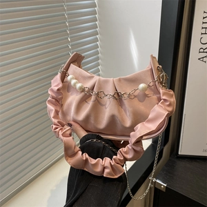 Pink pleated cloud bag with pearl accents and flower chain strap on shoulder