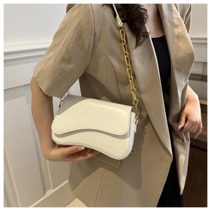 Detail of off-white underarm bag with wavy flap edge and thick gold chain strap