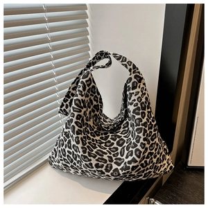 Detail of a large leopard print hobo tote bag made of thick woven fabric on a windowsill