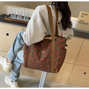 Détail du sac cabas en velours marron avec motif fraise rouge et poche latérale pratique
