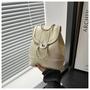 Détail du sac à dos en similicuir crème avec bandoulière chaîne et fermoir pivotant argent