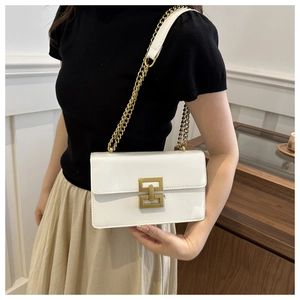 Détail du sac bandoulière blanc avec boucle dorée carrée et bandoulière chaîne