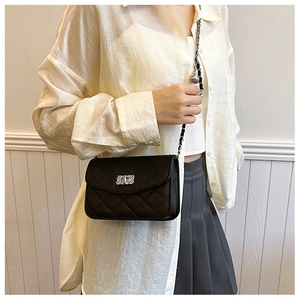 Détail du sac bandoulière en cuir matelassé noir avec fermoir argenté et chaîne
