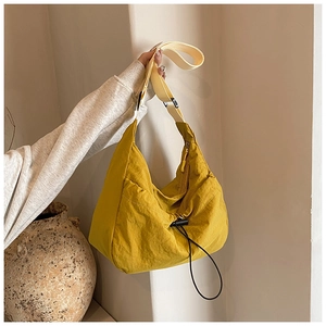 Detail of yellow nylon tote bag with drawstring ruffles and beige adjustable strap