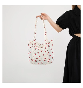 Detail of strawberry print tote bag showing the corduroy texture and sturdy handles