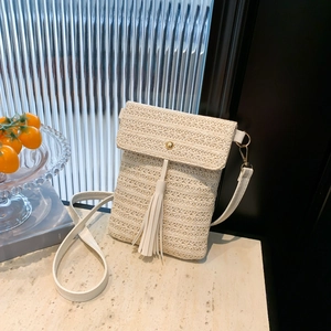 Elegant beige straw crossbody bag with white tassel and gold buckle for vacation style
