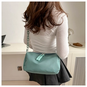 Détail du sac bandoulière vert menthe en tissu Oxford avec grosse chaîne en plastique