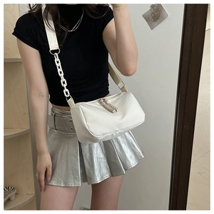 Détail d'un sac bandoulière blanc en nylon avec chaîne épaisse et double zip sur mannequin