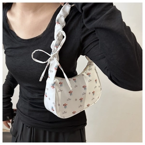Detail of white floral shoulder bag featuring a cute bow and 'Beautiful' print