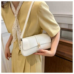 Gros plan d'un sac sous le bras blanc minimaliste avec un fermoir tournant doré