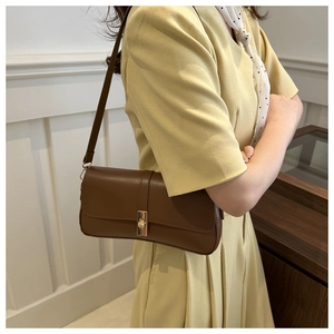 Vue détaillée d'un sac sous le bras en cuir marron avec boucle carrée dorée élégante