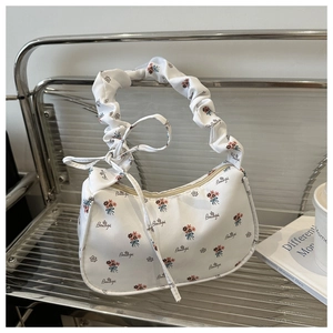 Detailed view of white floral tote with pleated handle and beautiful script print