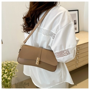 Détail du sac à bandoulière marron en similicuir avec fermoir rotatif doré sur le rabat