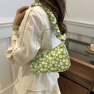 Floral print shoulder bag with drawstring ruching strap shown in a cozy indoor setting