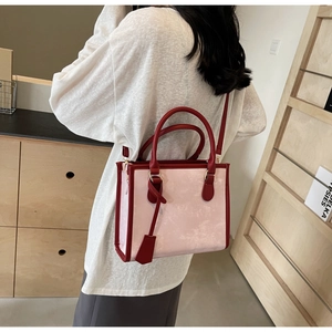 Vue détaillée du sac cabas rose et bordeaux porté par un mannequin pour l'échelle