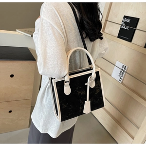 Détail d'un sac cabas chic en cuir noir et blanc avec des poignées doubles élégantes