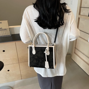 Sac fourre-tout contrasté avec corps noir texturé et anses blanc cassé sur modèle