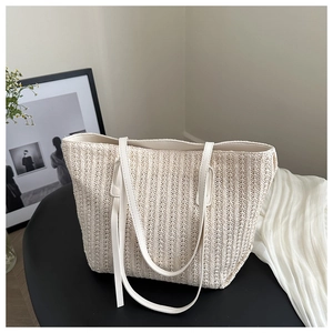 Detail of off-white woven tote bag with vertical texture and long leather straps