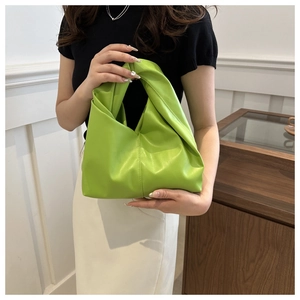 Dettaglio di una borsa a nuvola verde brillante con manico a nodo e texture a pieghe