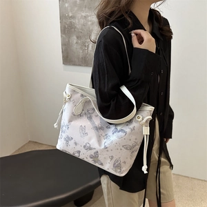 Grand sac cabas à motif papillon avec double bandoulière porté par un mannequin