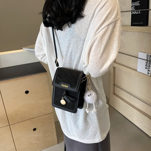 Fashionable black mini crossbody bag for women with cute plush charm and leather texture